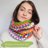 Model is a brunette white woman wearring one of the stripe cowls. the text in the bottom left corner lets you know this is the brights colourway