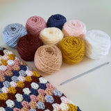 9 balls of yarn and a close up view of finished latte crochet cowl